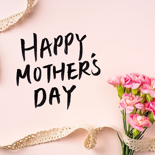 Happy Mother’s Day card on a soft pink background with a bouquet of pink flowers and a gold ribbon curling around it.