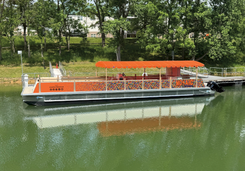 A colorful floating boat with orange canopy named 