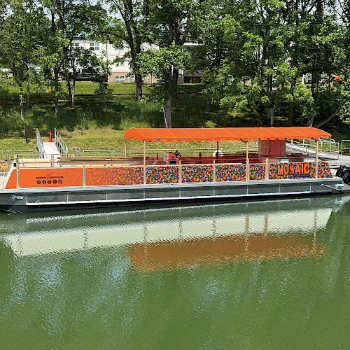 A colorful floating boat with orange canopy named 