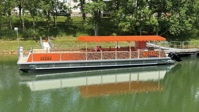 A colorful floating boat with orange canopy named 