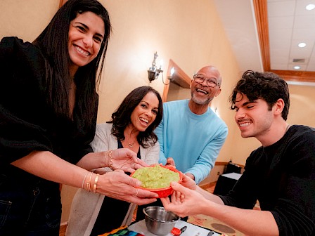 People sharing guacamole at a festive gathering, smiling and enjoying the moment.