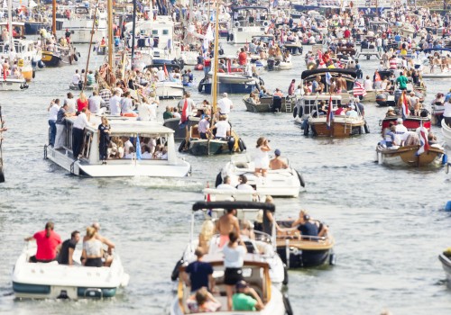 A crowded marina with numerous boats and many people enjoying a lively day on the water.