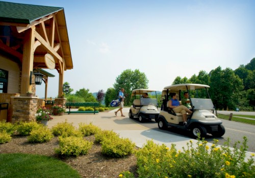 People arriving at a golf course, boarding golf carts near a clubhouse on a sunny day.