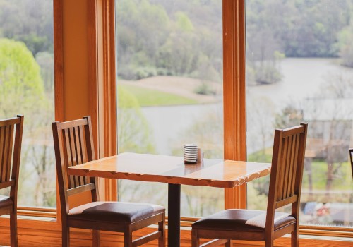 A table and two chairs against picturesque floor to ceiling windows. The table is open for guests to sit and dine.