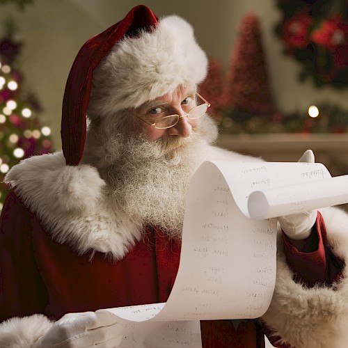 A person dressed as Santa Claus is holding a long list, with a decorated Christmas tree and festive background visible.