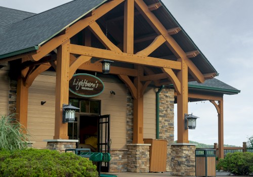 The image shows the entrance of a building with wooden beams, stone accents, and has a sign that reads 