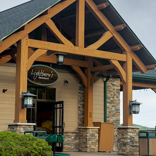 The image shows the entrance of a building with wooden beams, stone accents, and has a sign that reads 