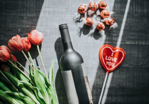 A bottle of wine, tulips, chocolate truffles, and a heart with 