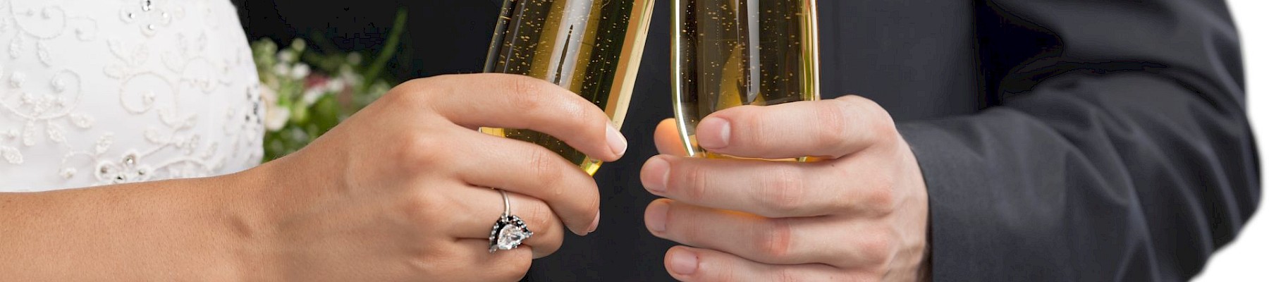 A couple in formal attire toasting with champagne flutes, bouquet of flowers visible, suggesting wedding celebration.