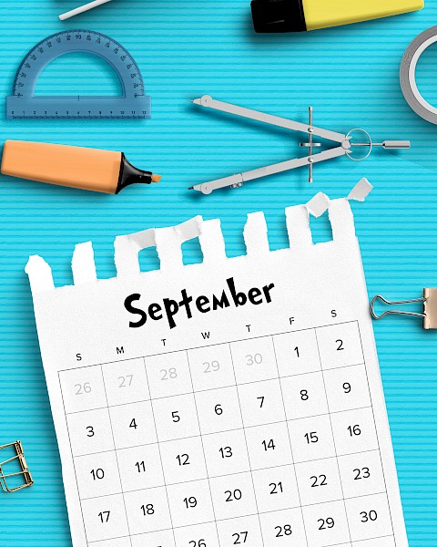 A September calendar page on a blue background with various stationery items like a protractor, highlighter, compass, and tape.