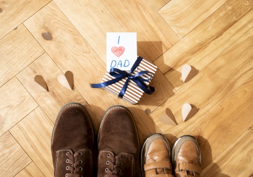 A pair of adult and child shoes, a gift wrapped in stripes with 