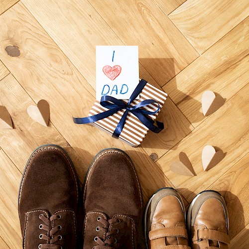 A pair of adult and child shoes, a gift wrapped in stripes with 